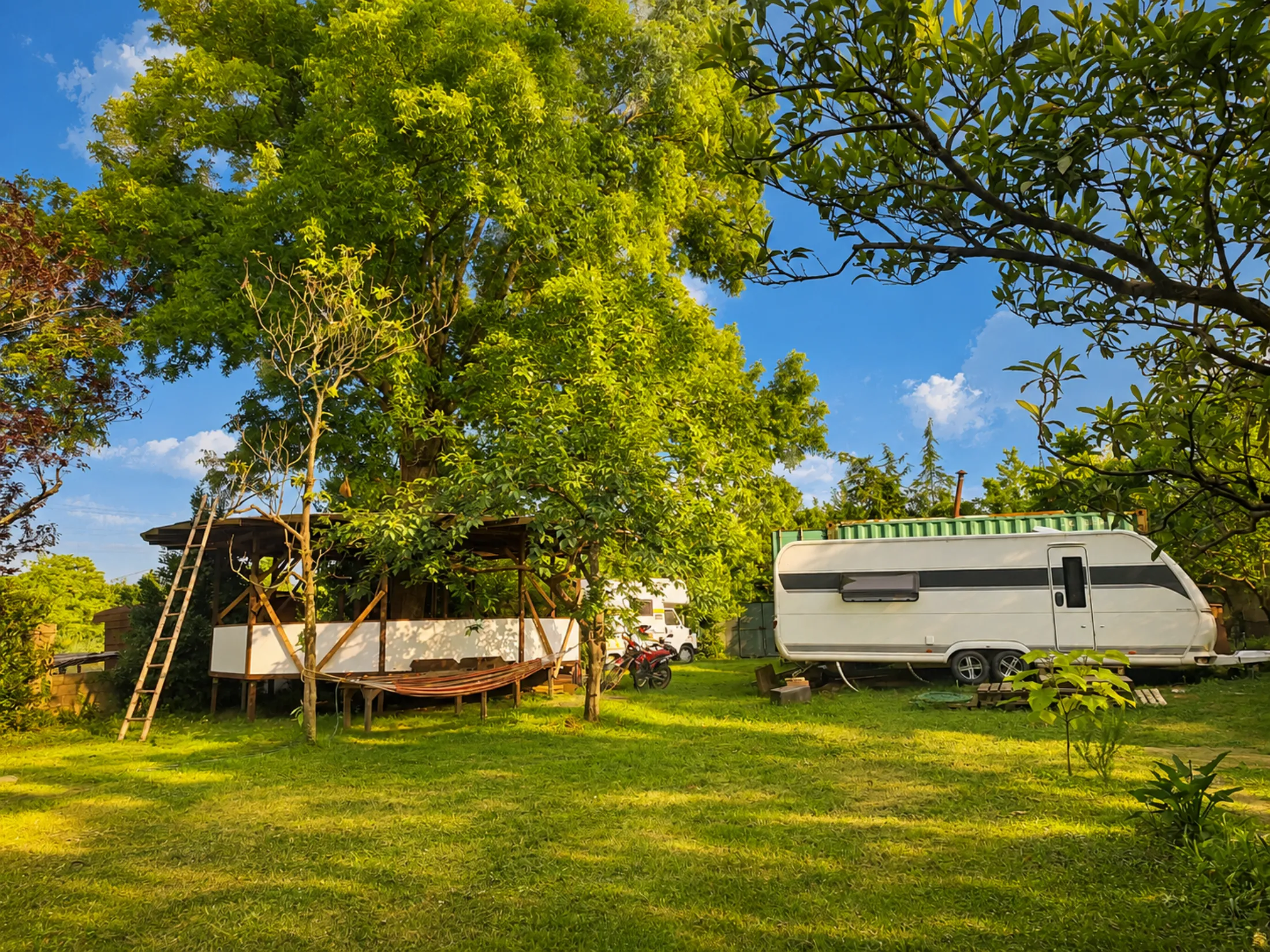 The Firefly Caravan and shaded deck in the green garden at Nomad Garden, Maltakva, Poti